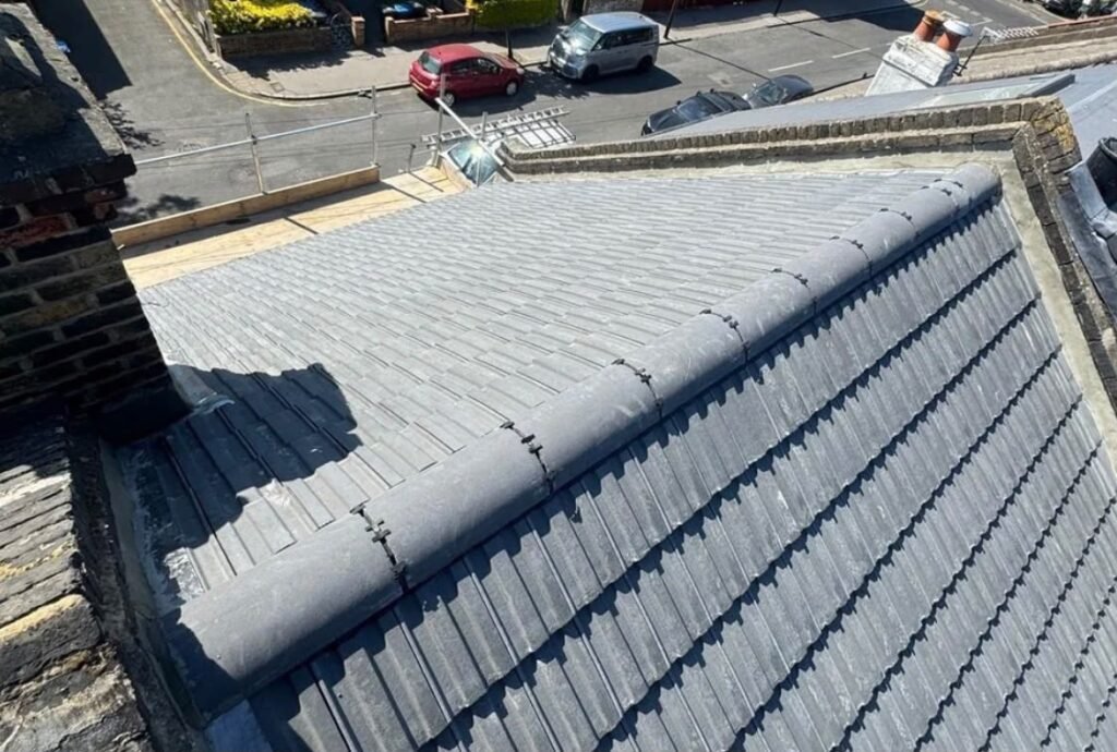 Newly laid grey interlocking tile roof with mechanically fixed ridge