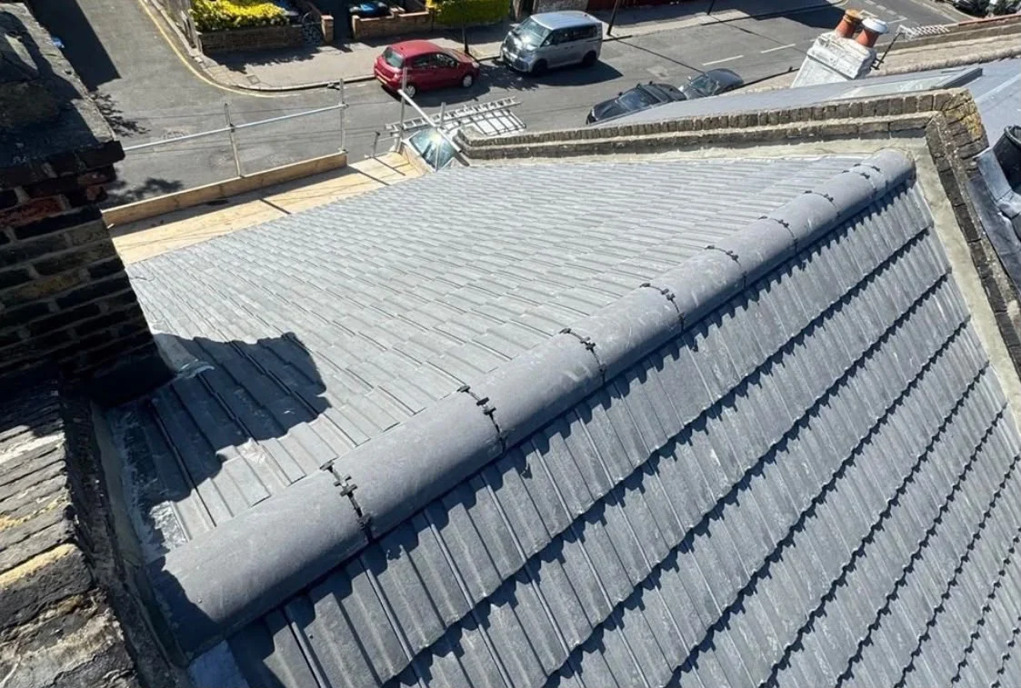 Newly laid grey interlocking tile roof with mechanically fixed ridge